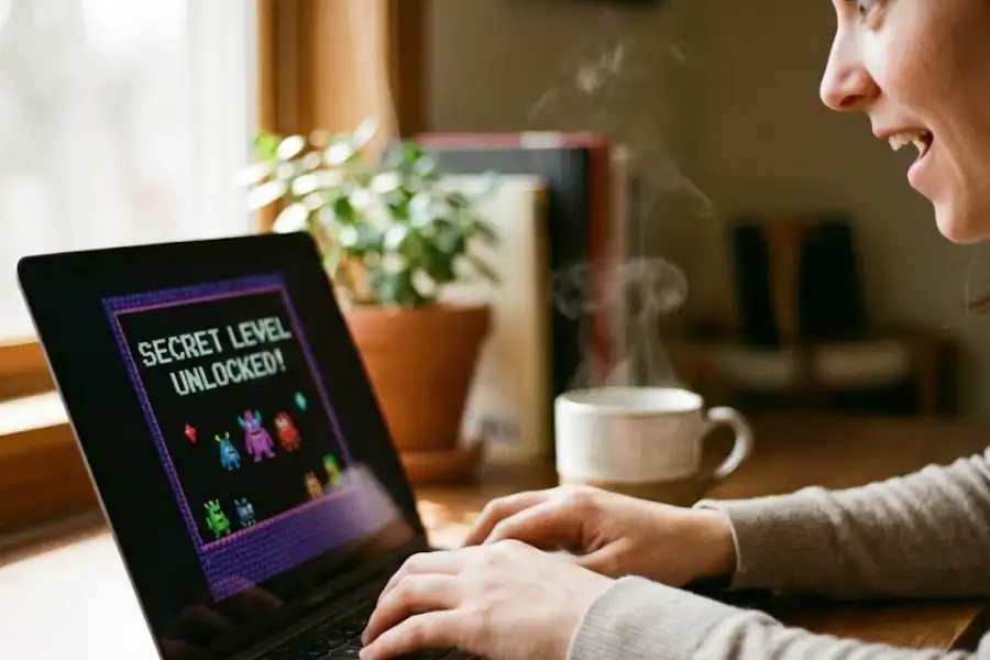 Person playing a video game on a laptop with the message “Secret Level Unlocked” displayed on the screen.