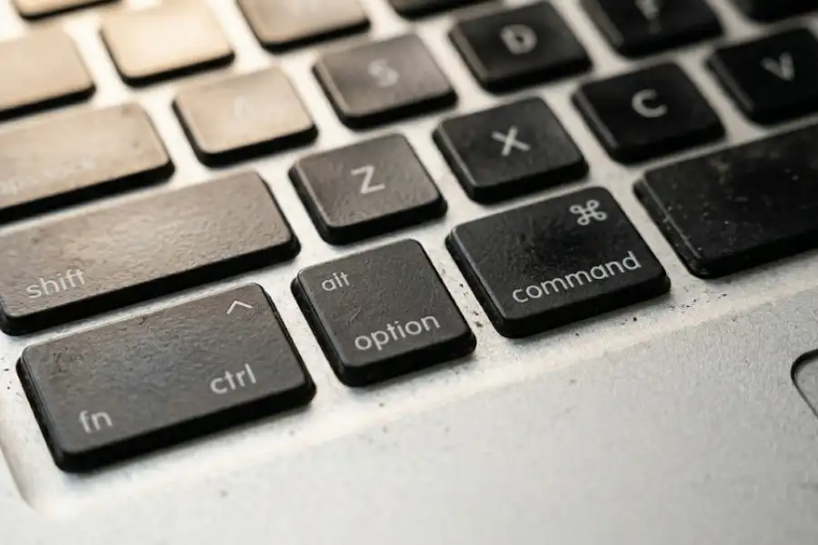 Macro close-up of MacBook keyboard showing the Command key with four-petal flower symbol and Option key