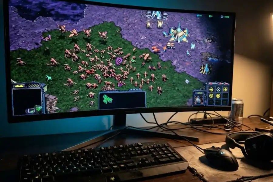 Zerg Rush Easter Egg: How to Play Google's Hidden Game in 2026 2 Gaming desk setup with the classic StarCraft strategy game running on a monitor showing a Zerg unit swarm