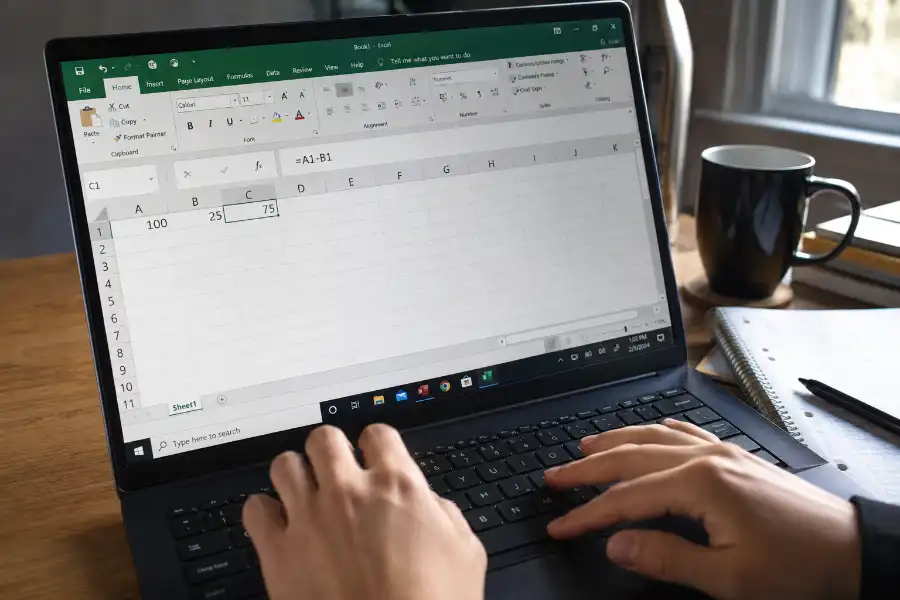 Laptop screen showing an Excel spreadsheet with a subtraction formula in the formula bar